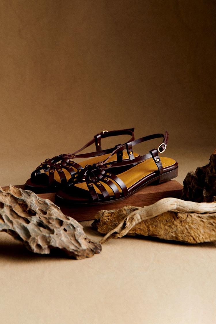 Dark brown sandals with metal studs and cutouts