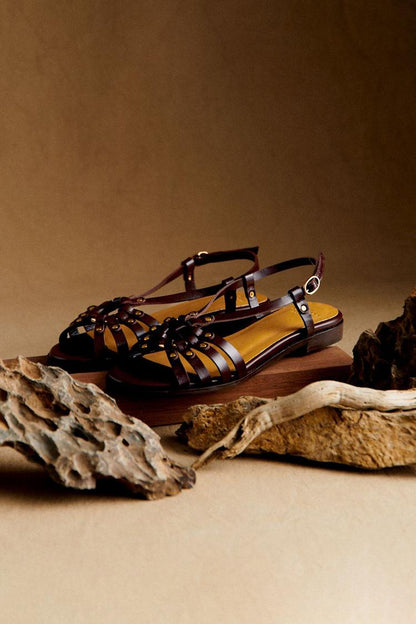 Dark brown sandals with metal studs and cutouts