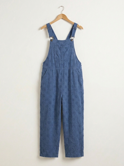 Blue linen dungarees on a wooden hanger