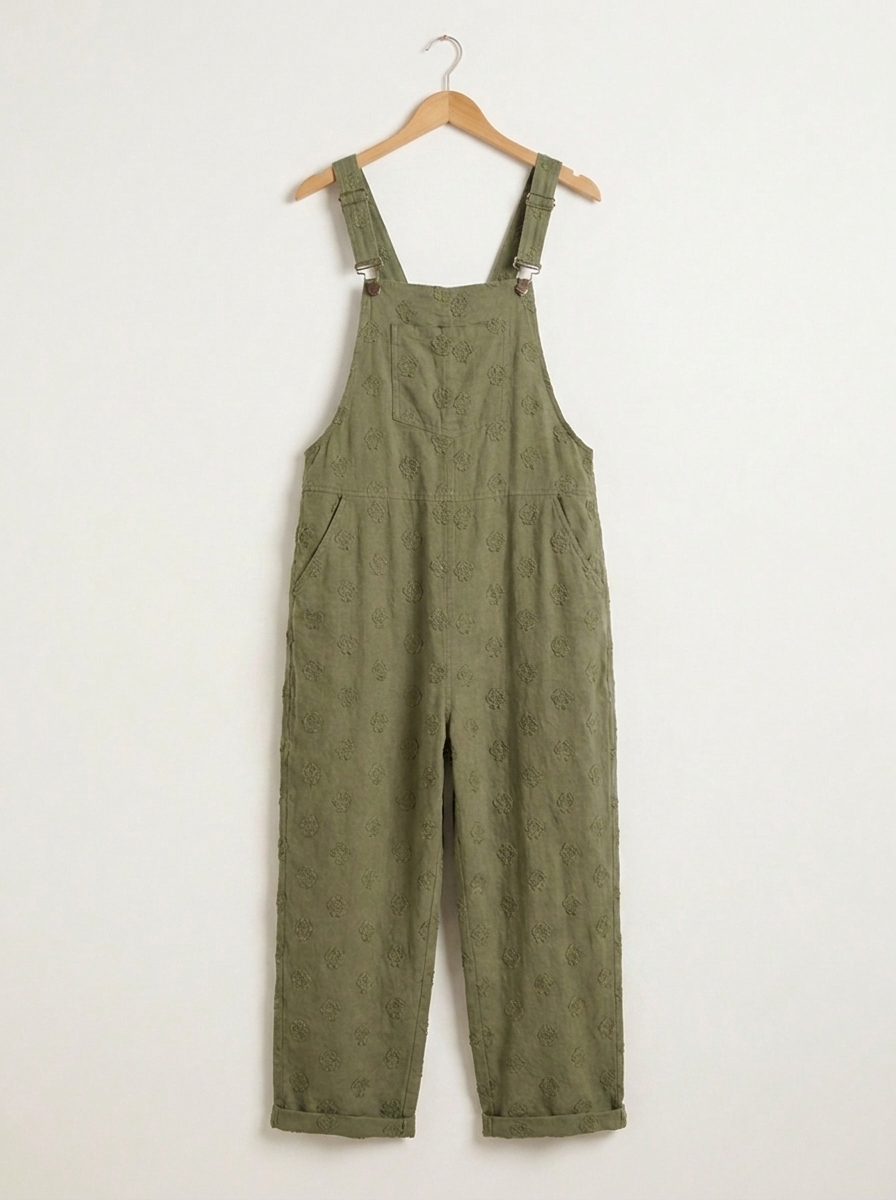 Green linen dungarees on a wooden hanger