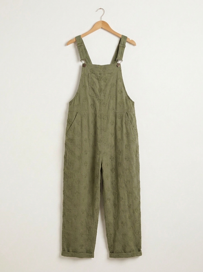 Green linen dungarees on a wooden hanger