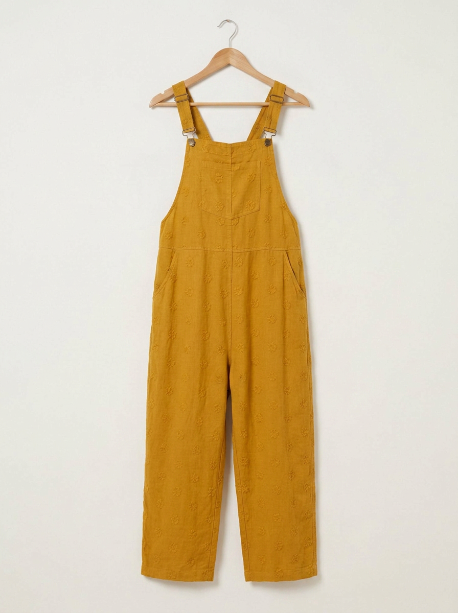 Yellow linen dungarees on a wooden hanger