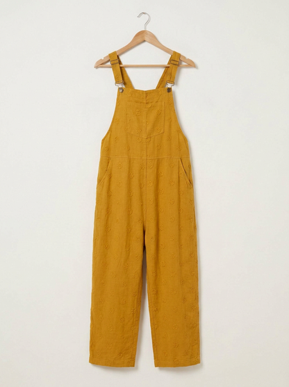 Yellow linen dungarees on a wooden hanger