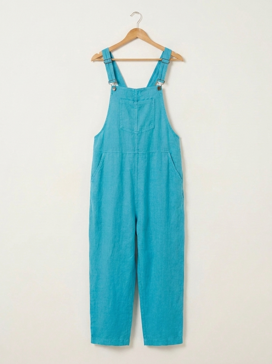 Turquoise linen dungarees on a wooden hanger
